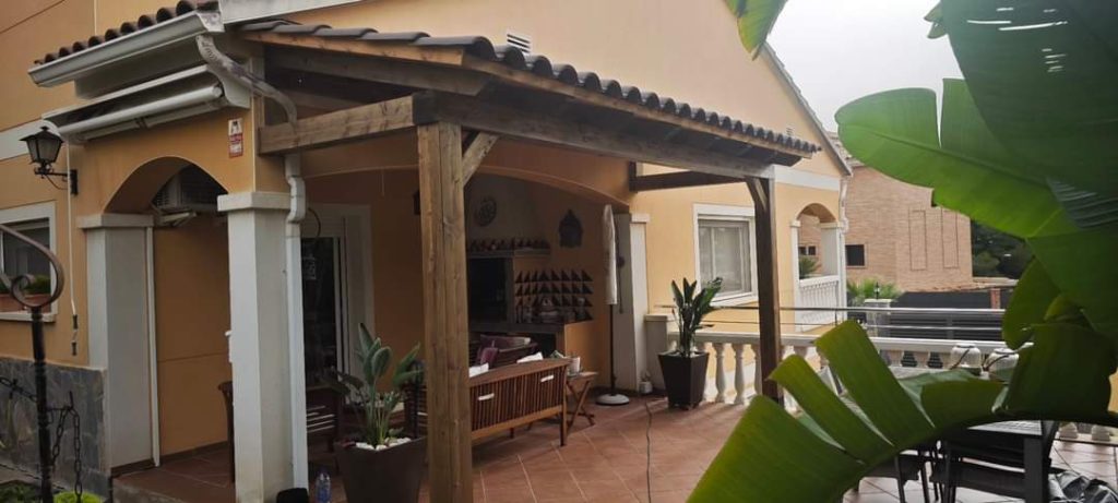 Reinforced wooden pergola on a restaurant terrace with diners underneath.